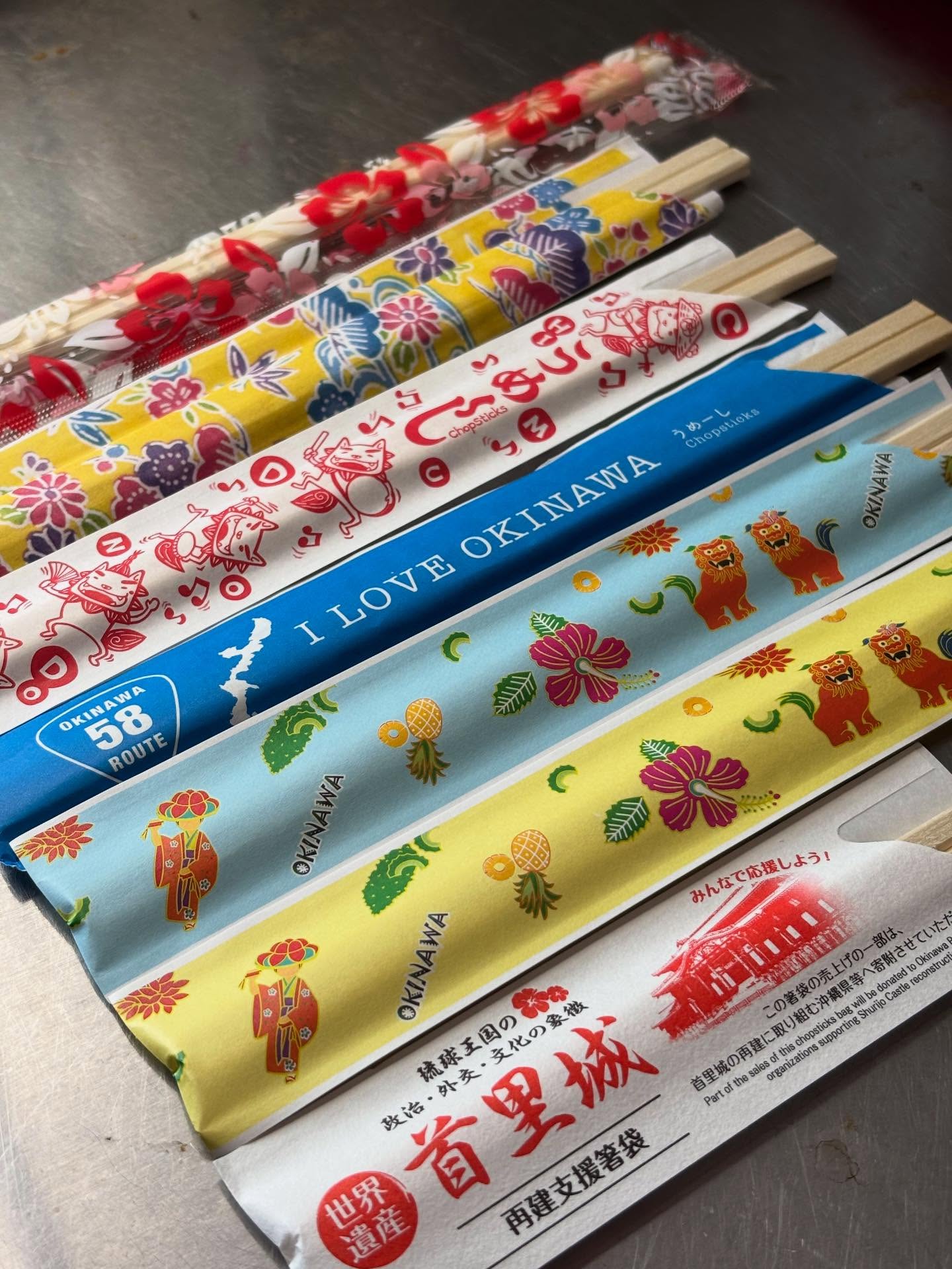 ・
・
ずっと続けていること！

沖縄へ行くたびに、現地で割り箸を買って帰ってきます🥢

スーパーで見つけたり、昔ながらの商店で偶然出会ったり、業務用のお店を探して買ったり。

中には田舎の商店でしか見かけないような柄もあって、そんな出会いも楽しみのひとつです♪

沖縄が大好きなので、かわいいデザインを見つけると、つい買ってしまいます。

お食事だけでなく、こういう小さなところからも沖縄を感じていただけたら嬉しいです。

これからも沖縄へ行くたびに新デザインを見つけたら沢山買ってこようと思ってます！

ご来店の際は、「今日はどの柄かな？」
なんて、そんなところも楽しんでいただけたら嬉しいです️

最新のデザインは首里城の再建支援箸袋で売上の一部が寄付されるそうです。